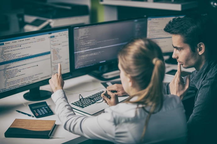 web developers viewing a screen of code