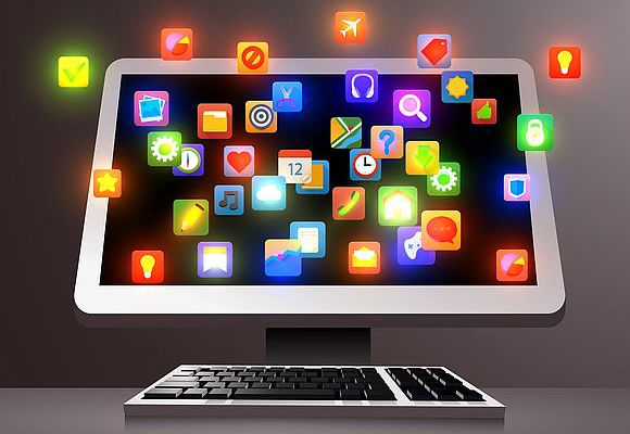 Computer with cloud of app icons on the screen. 