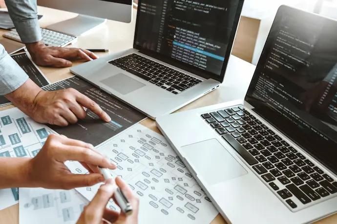 tech people at a computer with notes